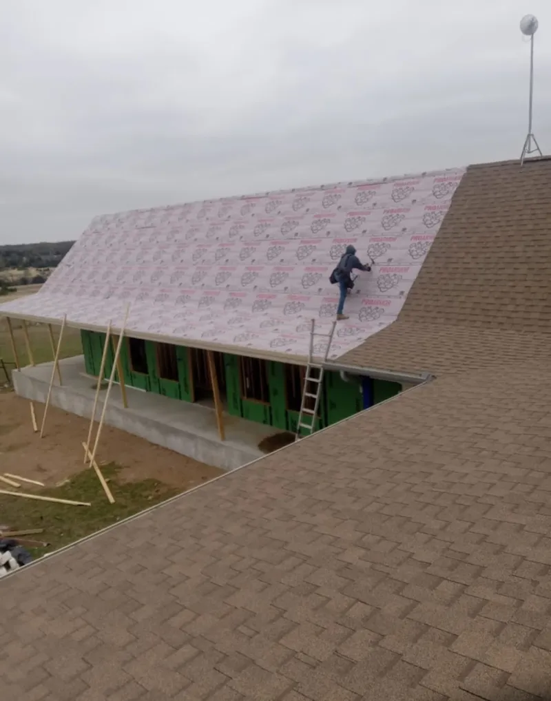 Worker preparing underlayment for a metal roof installation in Haiku-Pauwela
